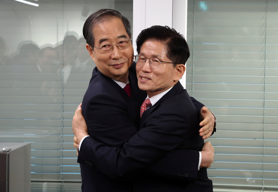Former Prime Minister Han Duck-soo, left, and People Power Party (PPP) presidential candidate Kim Moon-soo share a hug after their meeting on May 11 at the PPP headquarters in western Seoul. [JOINT PRESS CORPS]