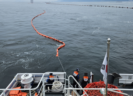 Authorites work to remove the spilled diesel fuel off the coast of Changown, South Gyeongsang, on May 11. [CHANGWON COAST GUARD STATION]