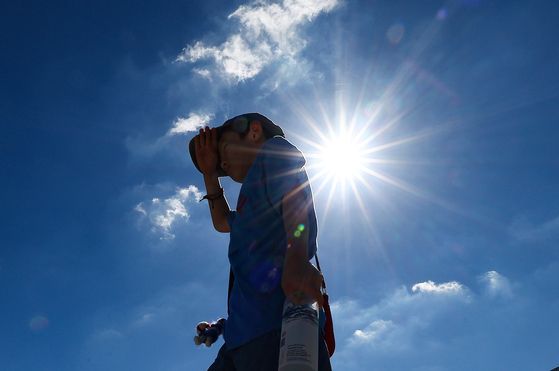 A child tries to block the sun during a heatwave in Daegu on July 31, 2024. [YONHAP]