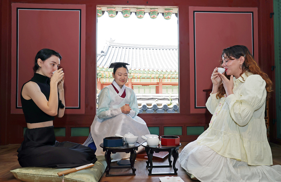 Foreign tourists experience royal Korean sweets at Changdeok Palace in Jongno District, central Seoul, on May 12. [NEWS1]