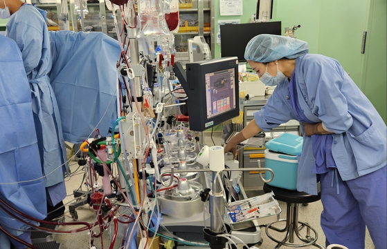 Oh Ji-young, a clinical perfusionist, operates a heart-lung machine during cardiac surgery. Perfusionists manage more than 10 devices during procedures, including a heart-lung machine, autotransfusion system and temperature regulator, while monitoring over six screens. [CHAE HYE-SEON]