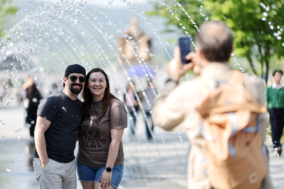 Tourists take a photo on a sunny afternoon in central Seoul on May 12. [YONHAP] 