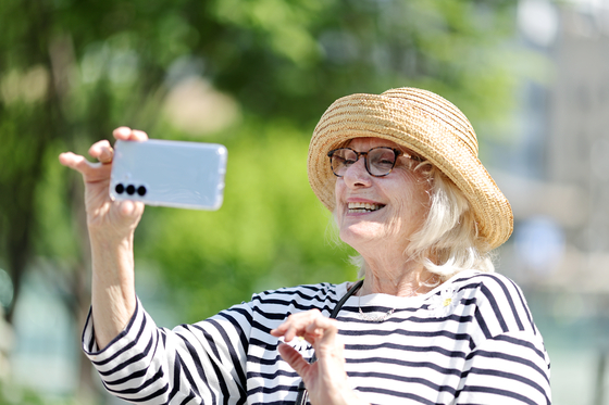 A woman takes a selfie on a sunny afternoon in central Seoul on May 12. [YONHAP]