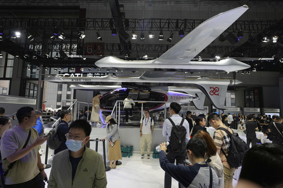 Visitors stand near a flying test platform from Chinese battery manufacturer CATL during the Shanghai auto show on April 23, 2025. [AP/YONHAP]