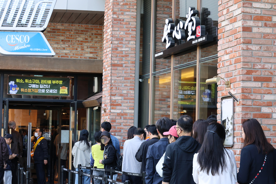 People line up outside the Sungsimdang DCC branch in Yuseong District, Daejeon, on April 27. [YONHAP]