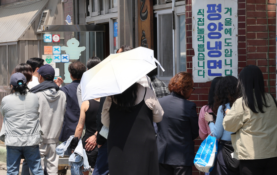 Citizens line up at a restaurant in Mapo District, western Seoul, serving cold noodles on May 13, when the highest degree forecast was 29 degrees Celsius (84 degrees Fahrenheit). [YONHAP] 