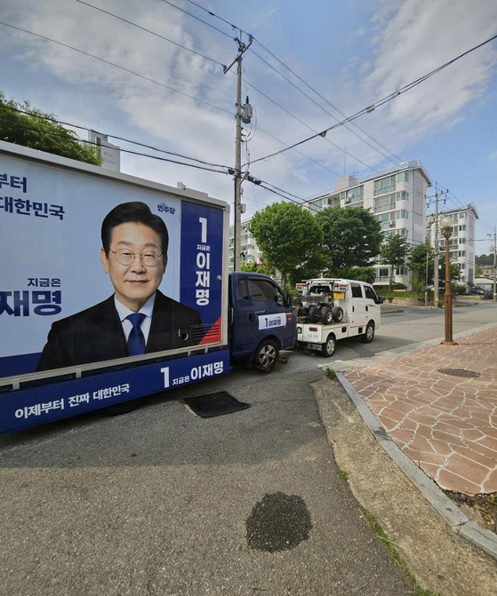A campaign truck of Democratic Party presidential candidate Lee Jae-myung is towed away on May 13. [DEMOCRATIC PARTY GANGWON BRANCH]