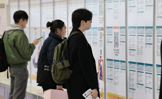 Job seekers checking job postings at an employment center in Seoul on Jan. 14. [YONHAP]