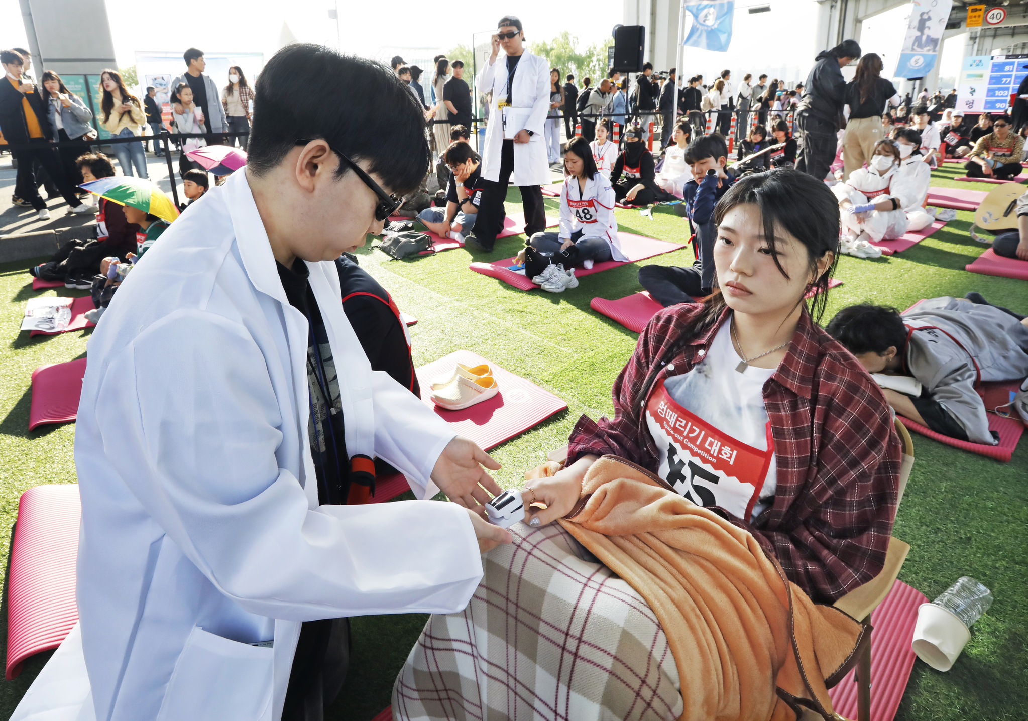 A stafffer checks a contestant's heart rate during the Hangang Space-out Competition in Seocho District, southern Seoul, on May 11. [PARK SANG-MOON]