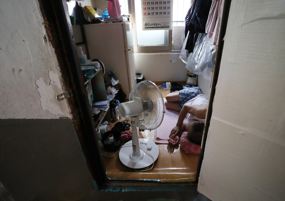 A resident cools down from the heat with an electric fan at a home in Jung District, central Seoul, on July 25, 2021. [NEWS1]