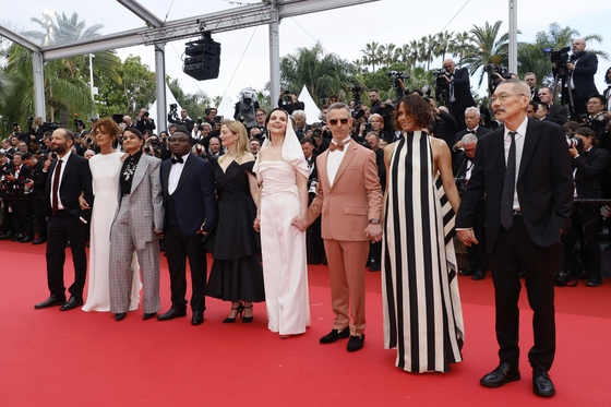 Jury president Juliette Binoche, fourth from left, and jury members Carlos Reygadas, Leila Slimani, Payal Kapadia, Dieudo Hamadi, Alba Rohrwacher, Jeremy Strong, Halle Berry and Hong Sang-soo pose for photographers during the opening ceremony red carpet of the 78th international film festival, Cannes, southern France, May 13. [AP/YONHAP]
