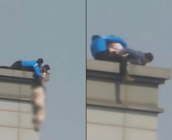 Police officers from the National Police Agency’s Special Operations Unit rescue a woman attempting to commit suicide by falling off a building in southern Seoul on May 2. [JOONGANG ILBO]