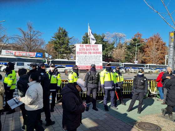 Police stand in front of a picket sign that denounces former Democratic Party leader Lee Jae-myung as a North Korean communist spy in front of the National Assembly complex in western Seoul on Dec. 8, 2024. [KIM MIN-YOUNG]
