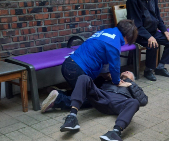 A campaign worker for Democratic Party presidential candidate Lee Jae-myung performs emergency CPR on a citizen who collapsed from cardiac arrest in a park. [SCREEN CAPTURE]