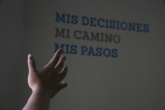 A health worker gestures towards a message that reads in Spanish; ″My decisions, my road, my steps″ during a tour of the MSI Foundation, an organization that offers information and help to women seeking abortions, in Mexico City, May 8. [AP/YONHAP]