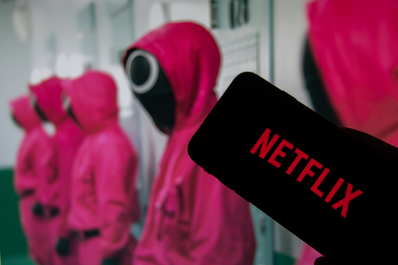 The Netflix logo is shown in front of the Pink Guards from ″Squid Game″ (2021-). [JOONGANG ILBO]