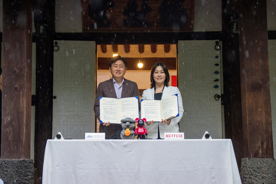 Kim Min-young, vice president of content for Asia at Netflix, right and Oh Young-hun, Jeju governor, left, pose for photos after a signing of a business agreement between Netflix and the Jeju Special Self-Governing Province on May 16. [NETFLIX]