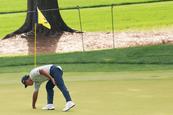Kim Si-woo pulls his ball from the cup on the sixth hole after a hole-in-one during the second round of the PGA Championship at Quail Hollow Country Club on May 16, in Charlotte, North Carolina. [GETTY IMAGES/YONHAP]