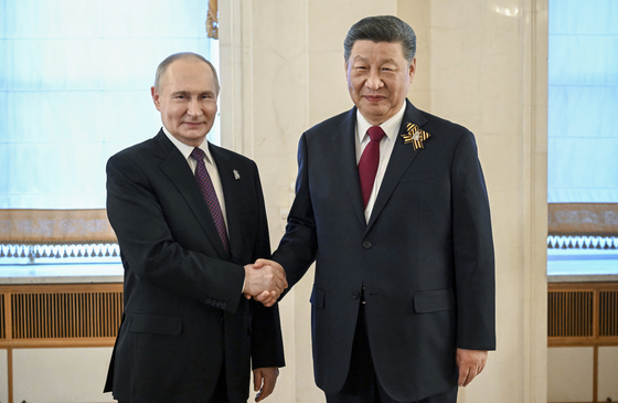 President of Russia Vladimir Putin and President of China Xi Jinping shake hands after arrival in the Kremlin for a gala concert held for heads of foreign delegations, in Moscow on May 8, 2025, ahead of celebrations of the 80th anniversary of the Soviet Union's victory over Nazi Germany during World War II. [AP/YONHAP]