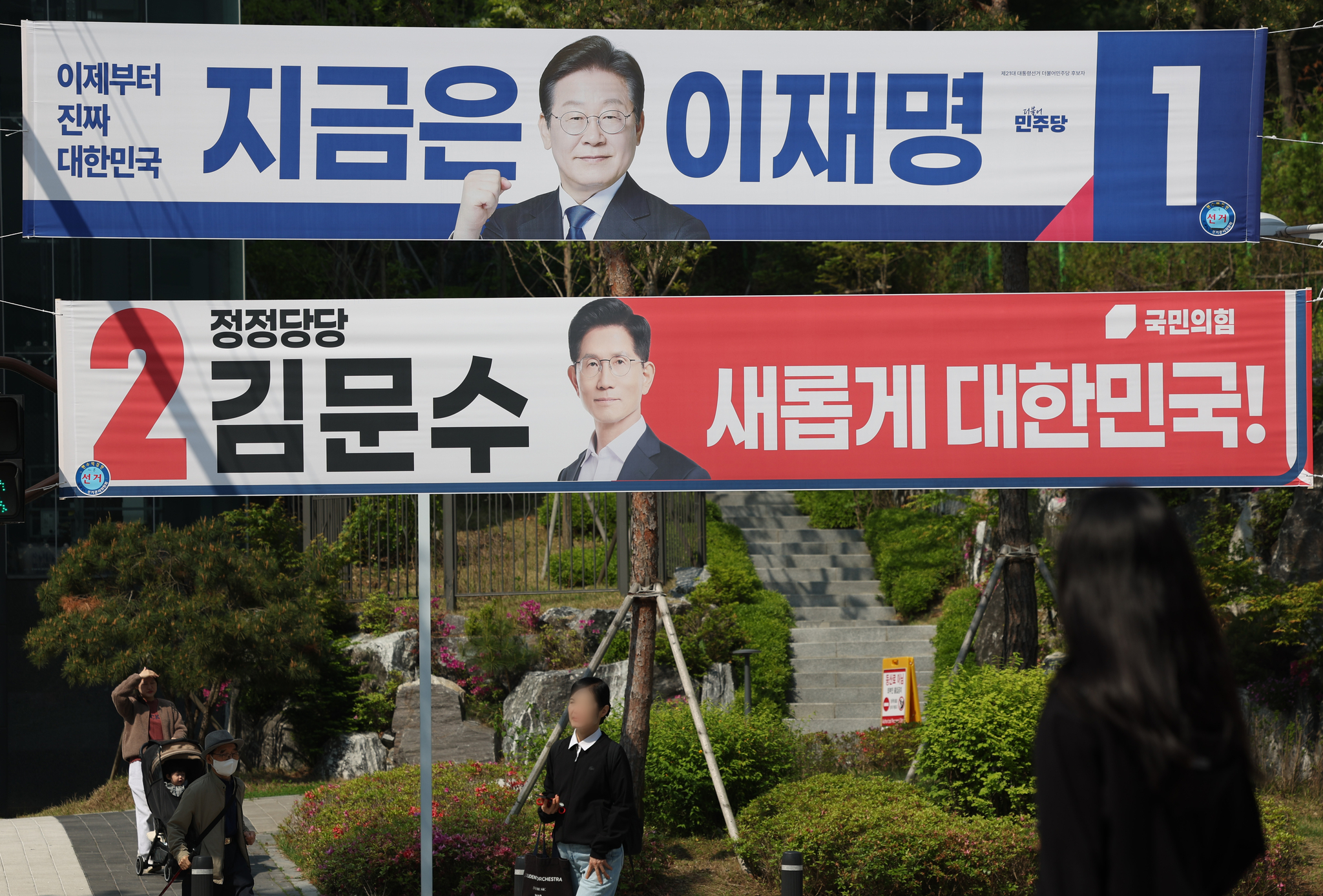 Banners for liberal Democratic Party candidate Lee Jae-myung and conservative People Power Party candidate Kim Moon-soo hang over a street in Seodaemun District, western Seoul, on the first official day of campaigning for the 21st presidential election on May 12. [YONHAP]