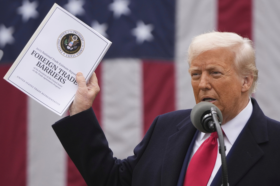 U.S. President Donald Trump holds the 2025 National Trade Estimate Report on Foreign Trade Barriers by the Office of the United States Trade Representative during an event to announce new tariffs at the White House in Washington on April 2. [AP/YONHAP]