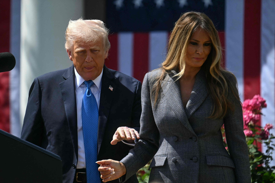 U.S. President Donald Trump and First Lady Melania Trump walk to a table to sign the ″Take It Down Act″ during a bill signing ceremony in the Rose Garden of the White House in Washington on May 19. [AFP/YONHAP]
