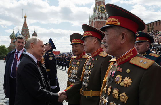 Russian President Vladimir Putin, left, greets North Korean army generals after a military parade on Victory Day marking the 80th anniversary of the victory over Nazi Germany in World War II, in Red Square in central Moscow May 9. [SPUTNIK/YONHAP]