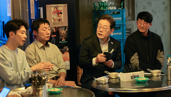 Democratic Party presidential candidate Lee Jae-myung, second from right, speaks with workers on non-standard contracts at a restaurant in Jongno District, central Seoul, on May 1. [JOINT PRESS CORPS]