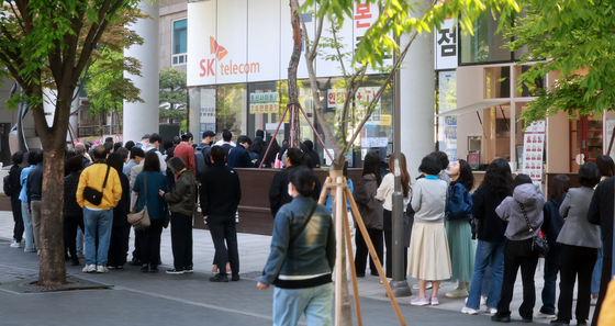 SK Telecom users wait in line to switch their SIM cards in front of a store in Jongno District, central Seoul on April 29. [NEWS1]