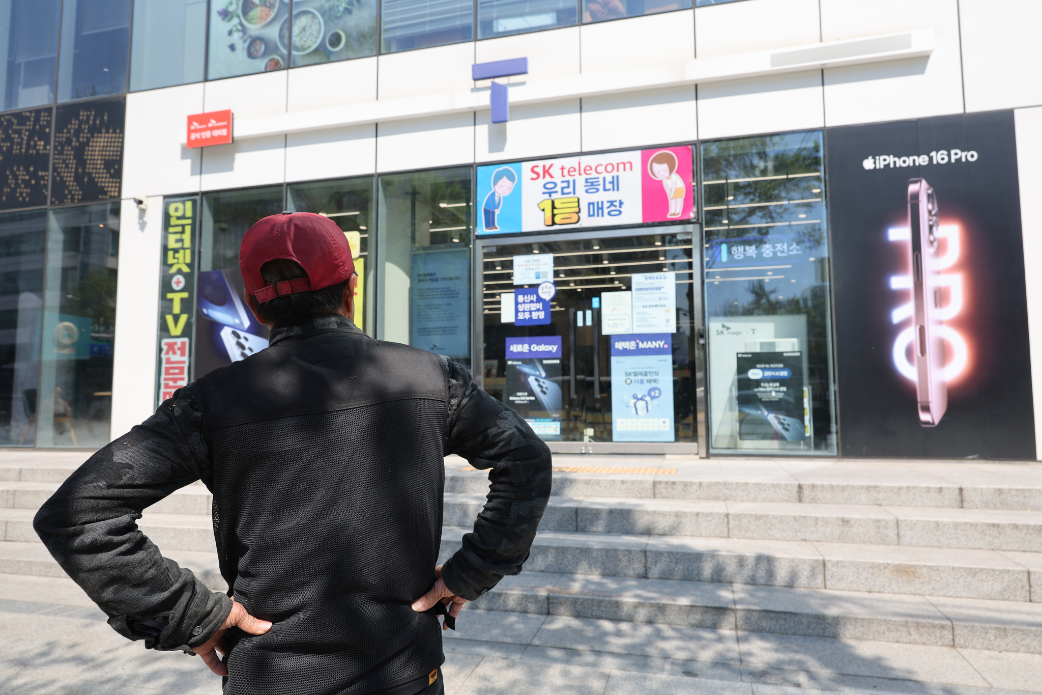 A person stands in front of an SK Telecom retail store in Seoul on May 2 to replace his subscriber identity module (SIM) card free of charge. [YONHAP]