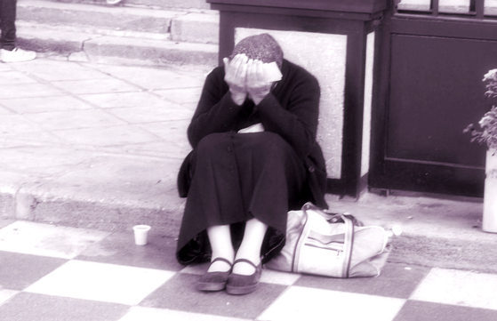 Stock photo of a woman burying her face in her palms on the curb [GETTY IMAGES]