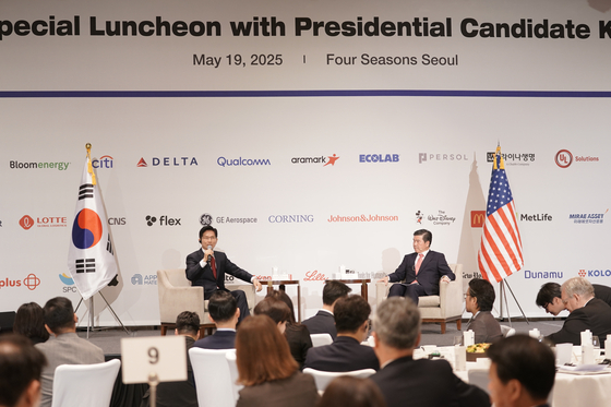 Presidential candidate Kim Moon-soo of the People Power Party, left, talks about his stance on Korea-U.S. cooperation with the American Chamber of Commerce in Korea Chairman James Kim during a luncheon in central Seoul on May 19. [AMCHAM]