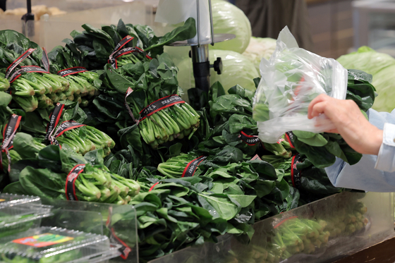 A customer bags spinach at a supermarket in Seoul on May 20. [NEWS1] 