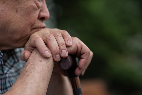 An older man leans on his cane. [GETTY IMAGES BANK]