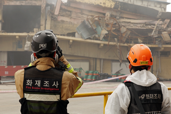 A fire investigator examines the scene at Kumho Tire’s Gwangju plant in Sochon-dong, Gwangsan District, on May 20, after officials declared the fire fully extinguished four days after it began. [NEWS1] 