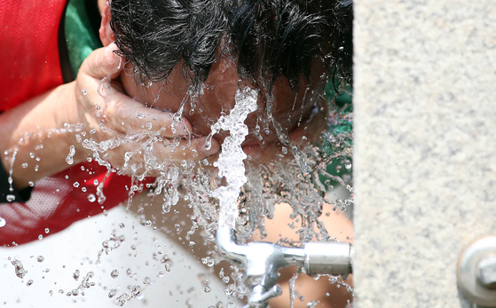 A person washes their face in a park fountain in Gwangju on June 14, 2024. [GWANGJU BUK DISTRICT OFFICE]