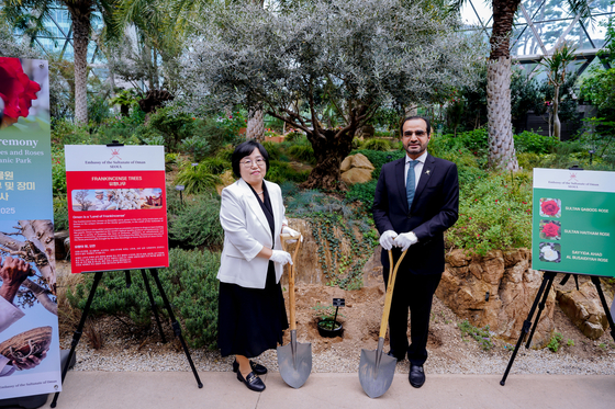 Omani Ambassador to Korea Zakaria bin Hamad Hilal Al Saad, right, and Seoul Botanic Garden Director Park Soo-mi pose for a photo at a ceremonial tree planting event organized by the embassy at the garden in Gangseo District, western Seoul, on May 19. [EMBASSY OF OMAN IN KOREA]