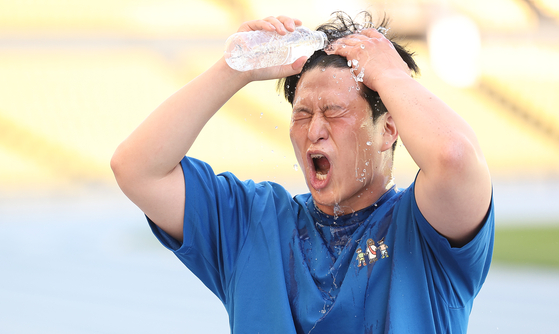 A person washes their face with water in Daegu on May 20 as temperatures surged up to 33.4 degrees Celsius (92 degrees Fahrenheit). [YONHAP]