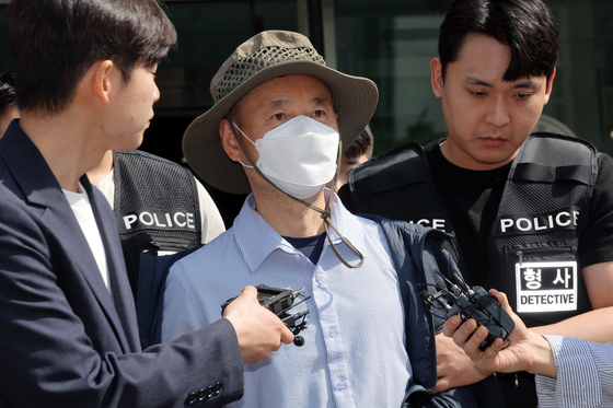 Che Zhenan, a 56-year-old Chinese national who killed two people and injured two others in a series of violent attacks in Siheung, Gyeonggi, leaves the Siheung Police Station on May 21 to attend questioning. [NEWS1]