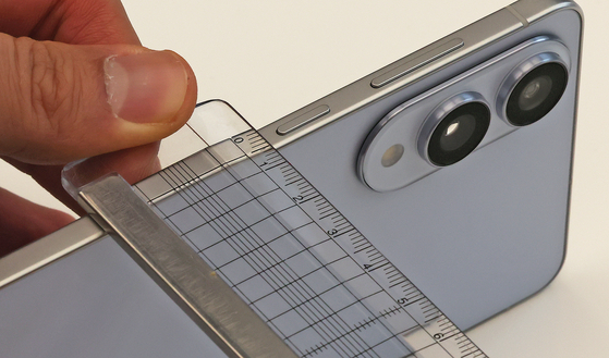 A ruler is used to measure the Galaxy S25 Edge, confirming its 5.8-millimeter thickness, at Samsung Electronics’ Gangnam branch in southern Seoul on May 13. [NEWS1]