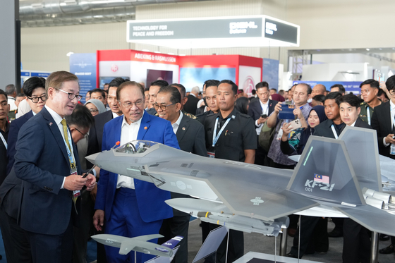 Kang Goo-young, CEO of Korea Aerospace Industries, far left, explains the domestically developed KF-21 fighter jet to Malaysian Prime Minister Anwar Ibrahim, second from left, during the LIMA 2025 defense exhibition in Langkawi, Malaysia, on May 20. [KOREA AEROSPACE INDUSTRIES] 