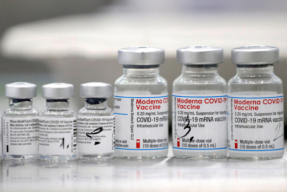 Vials of coronavirus disease (Covid-19) vaccines of Pfizer-BioNTech and Moderna are seen during a trial run of a mass vaccination center located inside of a gym in the town of Ricany near Prague, Czech Republic, February 25, 2021. [REUTERS/YONHAP]