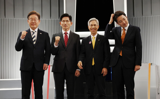 From left, Lee Jae-myung of the Democratic Party, Kim Moon-soo of the People Power Party, Kwon Young-gook of the minor Korean Democratic Labor Party and Lee Jun-seok of the minor Reform Party pose for a photo ahead of their first televised debate on May 23. [YONHAP] 