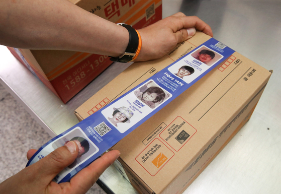 The "Hope Tape," tape containing the faces of 28 missing children, are being put on a parcel box in a post office in central Seoul on May 25, 2021, the day of the national Missing Children's Day. [JOONGANG ILBO]