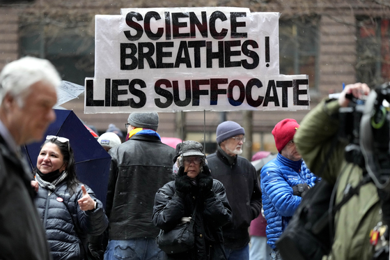A woman holds a sign during a Stand Up for Science rally protesting the Trump administration’s science policies and federal job cuts on March 7 in Chicago. [AP/YONHAP]