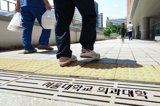 People walk into a medical school in downtown Seoul on May 25. [YONHAP]