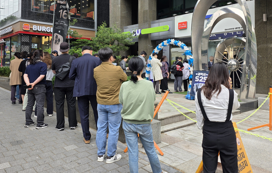 Customers wait in a line to replace their SIM cards in front of an official SK Telecom retailer in Seoul on May 20. [YONHAP]