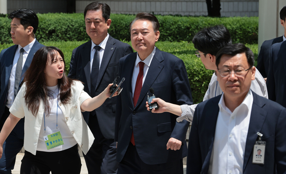 Former President Yoon Suk Yeol heads to his car after the fifth hearing of a trial over insurrection charges in connection with his declaration of martial law finishes at the Seoul Central District Court in southern Seoul on May 26, 2025. [JOINT PRESS CORPS]