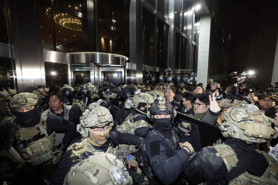 Citizens and National Assembly staff fend off soldiers from trying to enter the National Assembly building on Dec. 4, 2024, a day after former president Yoon Suk Yeol declared martial law. [JOONGANG ILBO]