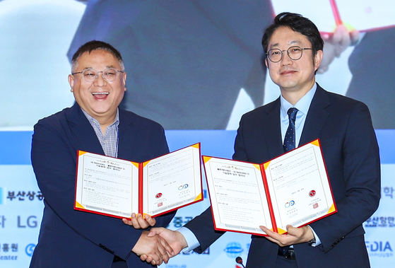 Kim Jong-seong, left, head of the Blue Carbon Research Center at Seoul National University and Kim Young-seok, head of LG Electronics' HS Functional Materials Business Division, pose for a commemorative photo during a blue carbook cooperation MOU signing event at Bexco in Busan on May 26. [LG] 